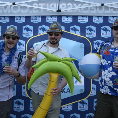 Ox fans holding inflatables in front of the Blue Ox logo backdrop