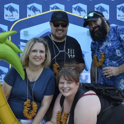 Ox fans holding inflatables in front of the Blue Ox logo backdrop