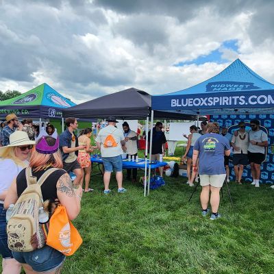 A group of people in front of the Blue Ox booth