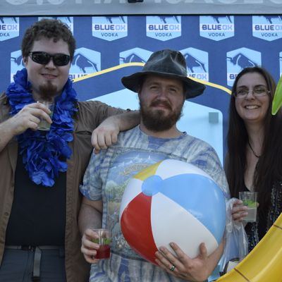 Ox fans holding inflatables in front of the Blue Ox logo backdrop