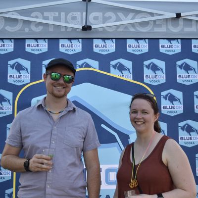 Ox fans holding inflatables in front of the Blue Ox logo backdrop