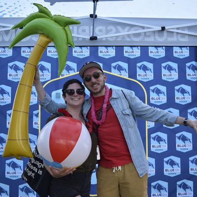 Ox fans holding inflatables in front of the Blue Ox logo backdrop