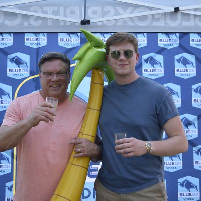 Ox fans holding inflatables in front of the Blue Ox logo backdrop